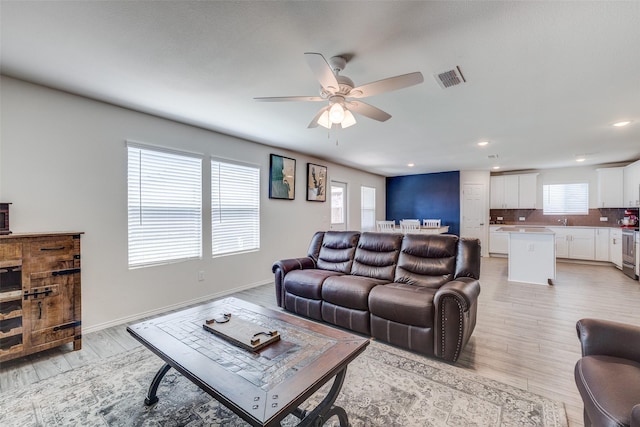 living area with a ceiling fan, visible vents, light wood-style flooring, and recessed lighting