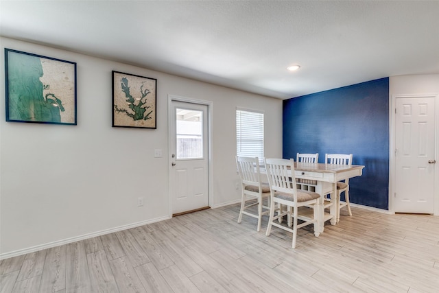 dining room with baseboards and light wood-style flooring