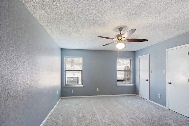 unfurnished room featuring a ceiling fan, carpet, and a textured wall