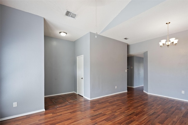 unfurnished room featuring a chandelier, visible vents, baseboards, and wood finished floors