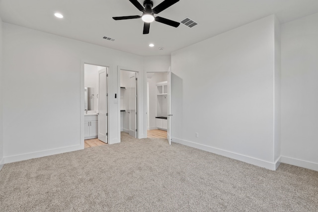 unfurnished bedroom with baseboards, light carpet, recessed lighting, a spacious closet, and visible vents