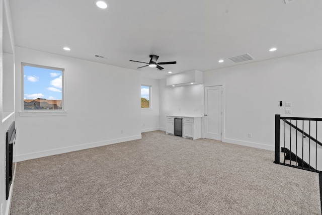 unfurnished living room with visible vents, baseboards, a ceiling fan, recessed lighting, and light carpet