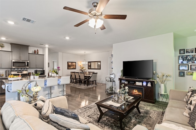 1703 Ratama Dr, Princeton, TX 75407 - living area featuring dark wood finished floors, ceiling fan, recessed lighting, a chandelier, and a lit fireplace