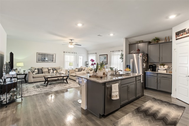 1703 Ratama Dr, Princeton, TX 75407 - kitchen with stainless steel appliances, open floor plan, light stone counters, a ceiling fan, and gray cabinetry