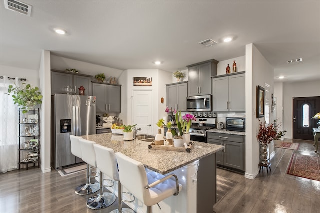 1703 Ratama Dr, Princeton, TX 75407 - kitchen with appliances with stainless steel finishes, gray cabinetry, dark wood-type flooring, an island with sink, and recessed lighting
