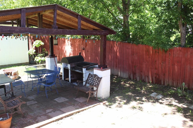 view of patio / terrace featuring outdoor dining area, a fenced backyard, grilling area, and a gazebo