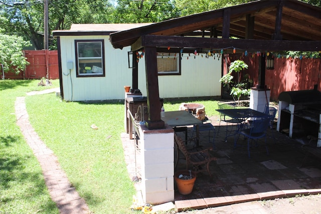 view of patio with an outdoor structure, a fenced backyard, and outdoor dining space