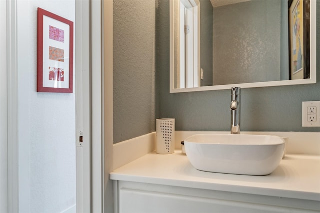 bathroom featuring a textured wall and vanity