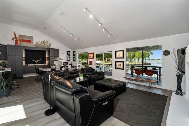 living area with visible vents, vaulted ceiling, baseboards, and light wood-style flooring