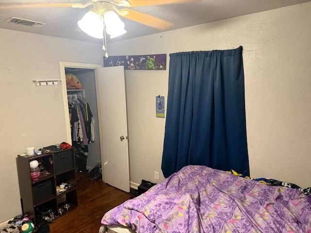 bedroom with ceiling fan, visible vents, a closet, and wood finished floors