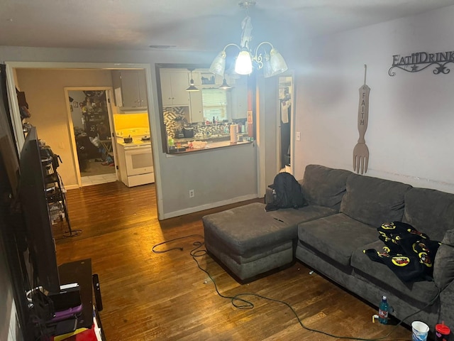 living area with baseboards, a chandelier, and dark wood finished floors