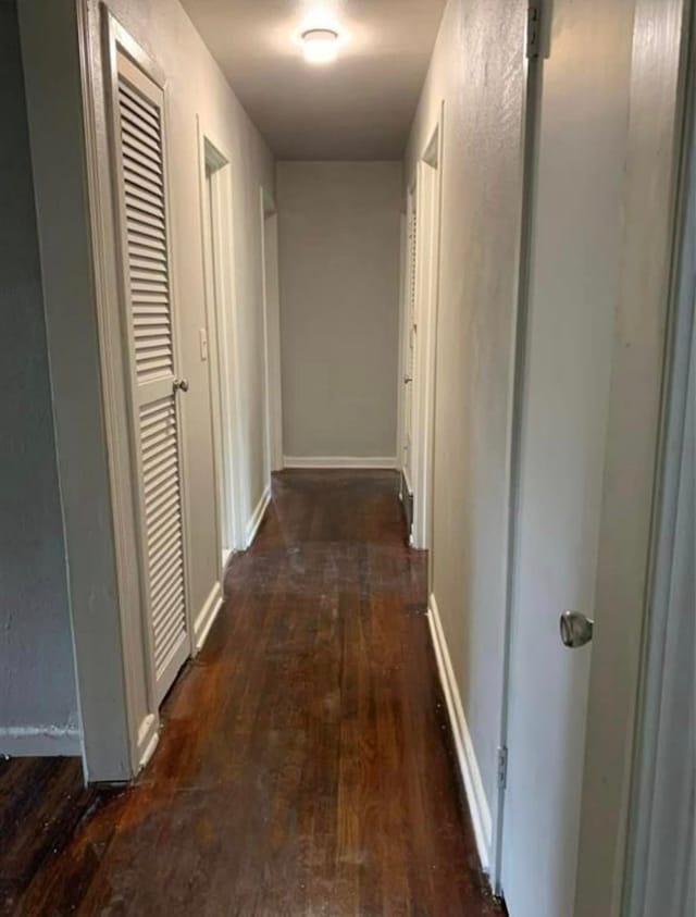 hall with baseboards and wood finished floors