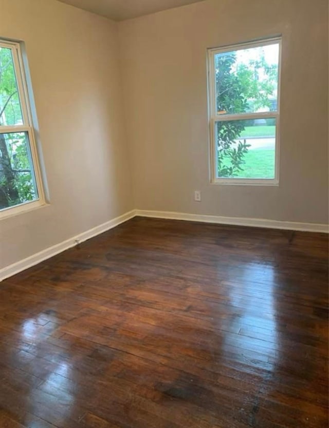empty room featuring dark wood-style flooring and baseboards