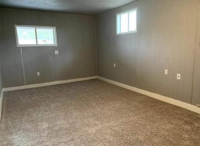 basement with carpet, baseboards, and a healthy amount of sunlight