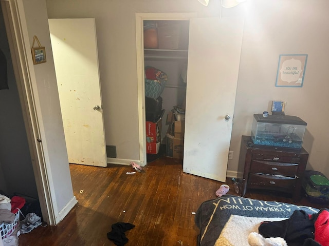 bedroom featuring a closet, baseboards, and hardwood / wood-style flooring