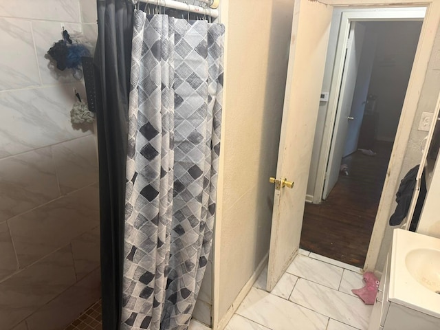 bathroom with a shower with shower curtain, vanity, and marble finish floor