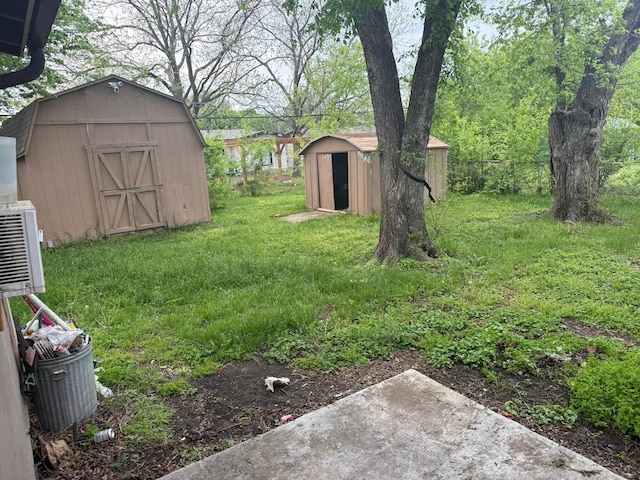 view of yard featuring an outbuilding, a storage unit, and fence