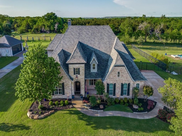 french country home with fence and a front lawn