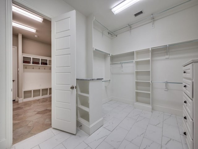 spacious closet with marble finish floor and visible vents