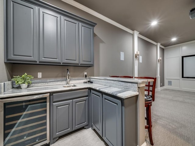 bar with a sink, beverage cooler, ornamental molding, light carpet, and recessed lighting