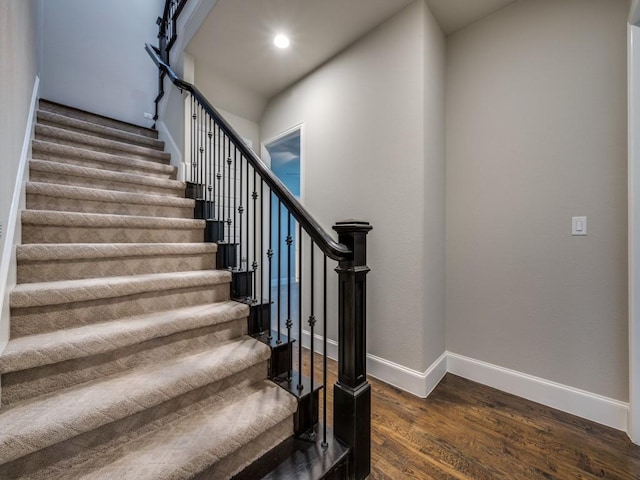 staircase featuring recessed lighting, baseboards, and wood finished floors