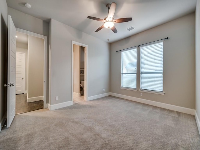 unfurnished bedroom featuring baseboards, ceiling fan, light carpet, and visible vents