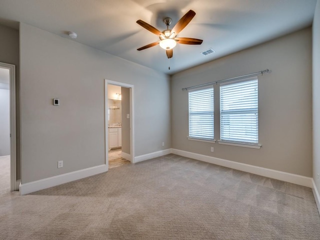 spare room featuring visible vents, baseboards, ceiling fan, and light colored carpet