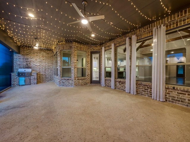 interior space featuring brick wall and ceiling fan