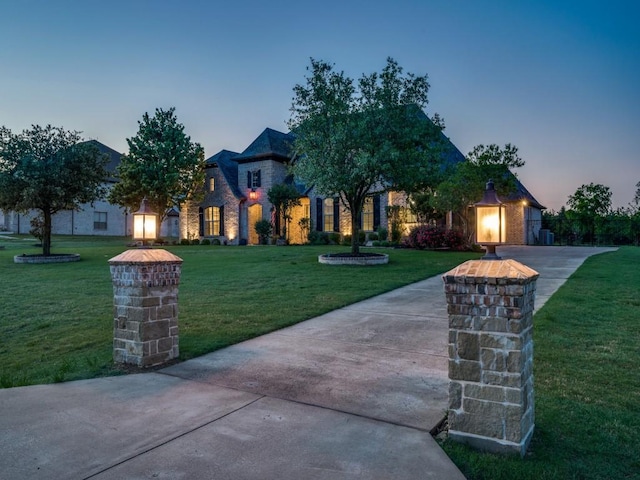french country inspired facade with a yard