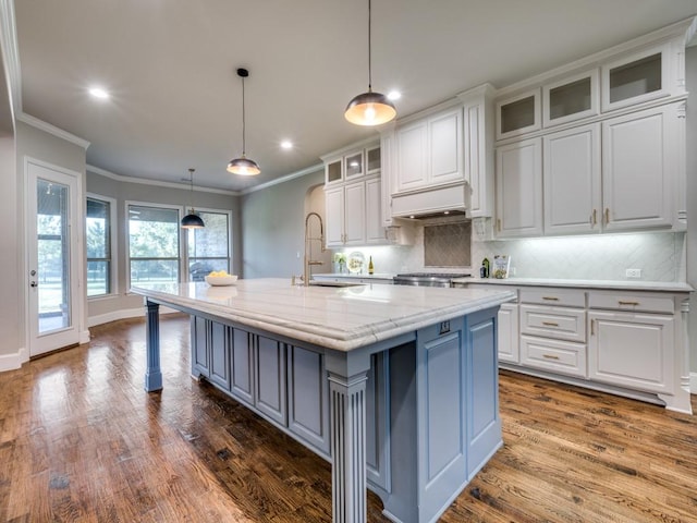 kitchen featuring white cabinets, ornamental molding, a sink, and tasteful backsplash