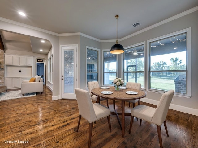 dining area with crown molding, baseboards, visible vents, and dark wood-type flooring