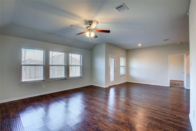unfurnished room featuring dark wood-type flooring, visible vents, a ceiling fan, and baseboards