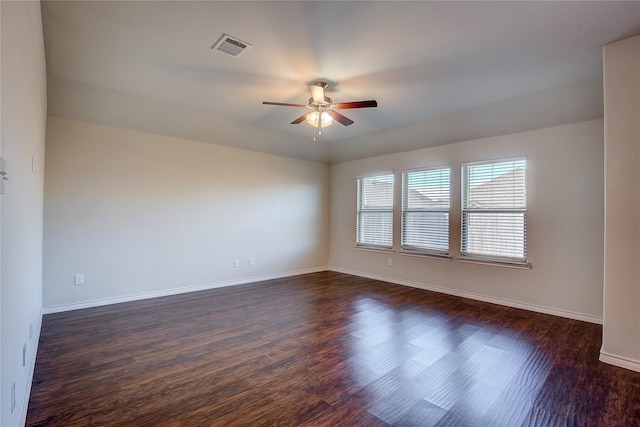 empty room with ceiling fan, baseboards, dark wood-style flooring, and visible vents