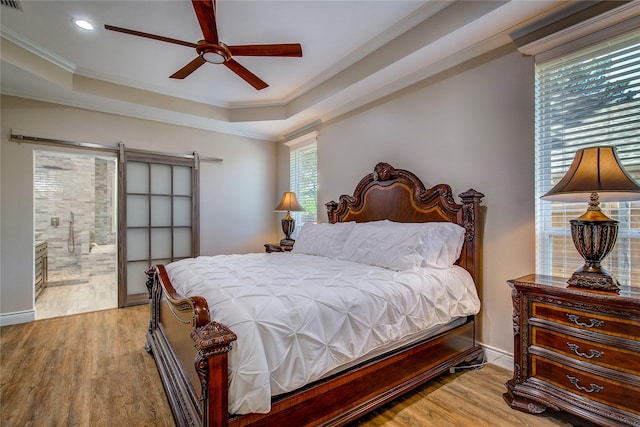 bedroom featuring a tray ceiling, crown molding, wood finished floors, and recessed lighting