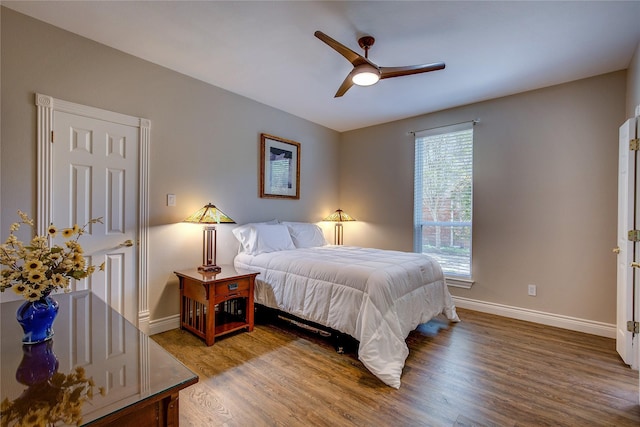 bedroom with baseboards, a ceiling fan, and wood finished floors