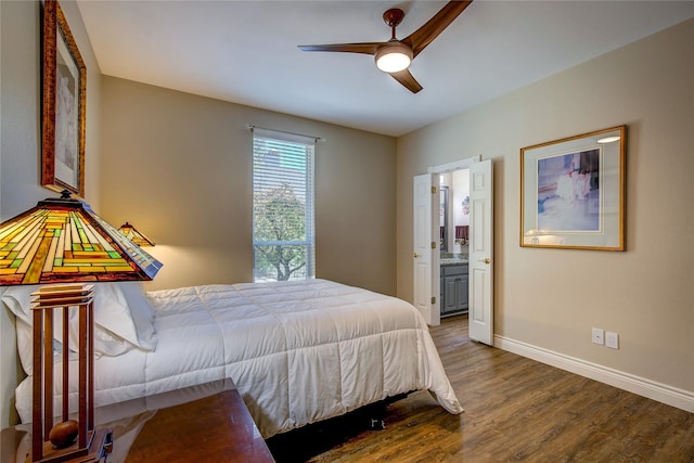 bedroom with baseboards, connected bathroom, ceiling fan, and wood finished floors