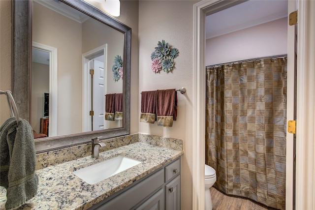 bathroom featuring crown molding, vanity, toilet, wood finished floors, and a shower with shower curtain