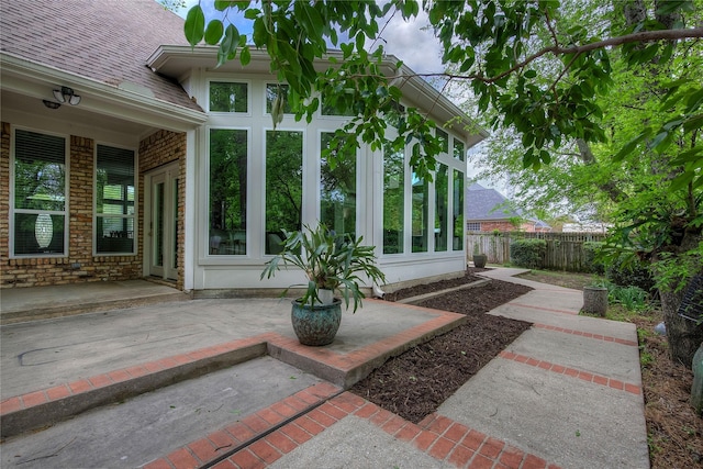 view of patio / terrace with fence and a sunroom
