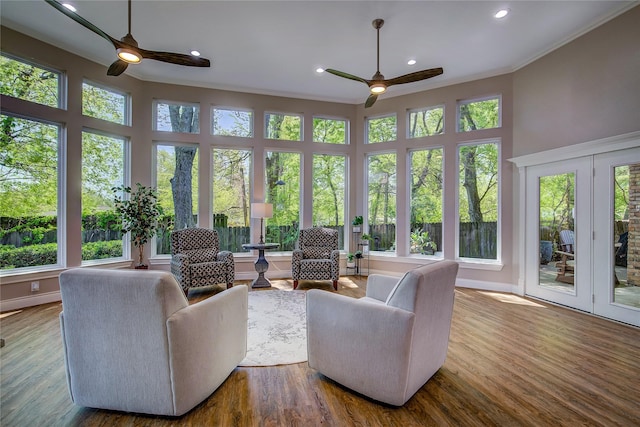 sunroom with a wealth of natural light, a deck, french doors, and crown molding