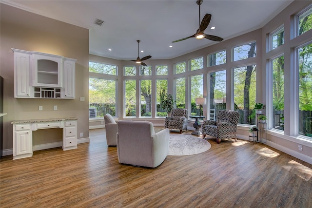 sunroom with a wealth of natural light, recessed lighting, baseboards, and wood finished floors