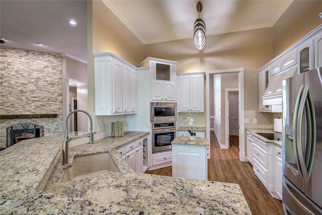 kitchen featuring appliances with stainless steel finishes, a sink, light stone counters, and white cabinets