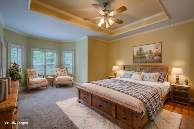 bedroom with baseboards, crown molding, and a raised ceiling