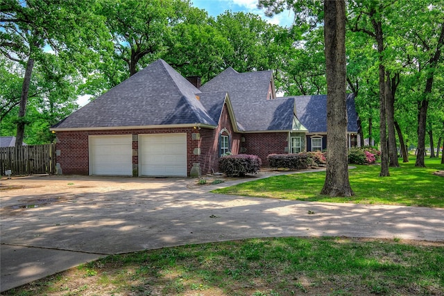 view of front of home with fence, concrete driveway, an attached garage, brick siding, and a front yard