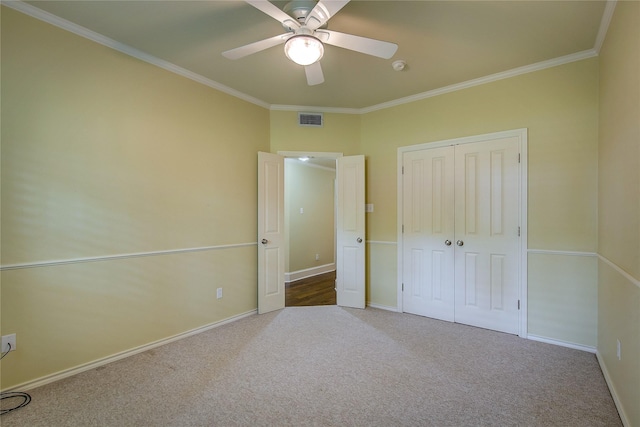 unfurnished bedroom with carpet floors, visible vents, and ornamental molding