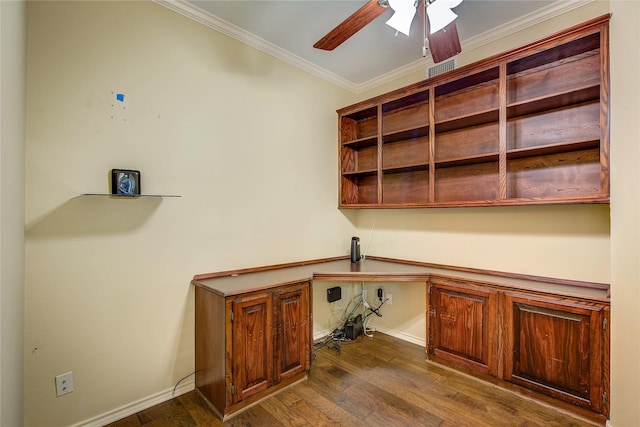 unfurnished office with crown molding, built in study area, ceiling fan, baseboards, and dark wood-type flooring