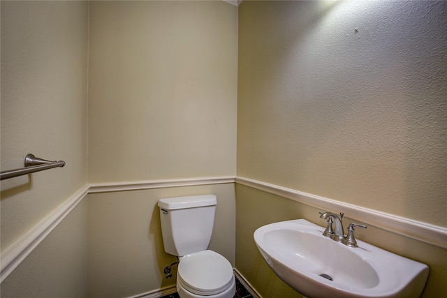 half bathroom with toilet and a sink