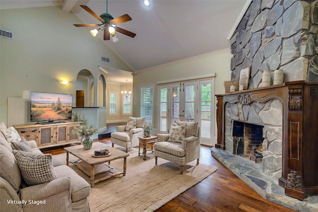 living room with visible vents, high vaulted ceiling, ceiling fan with notable chandelier, wood finished floors, and a fireplace