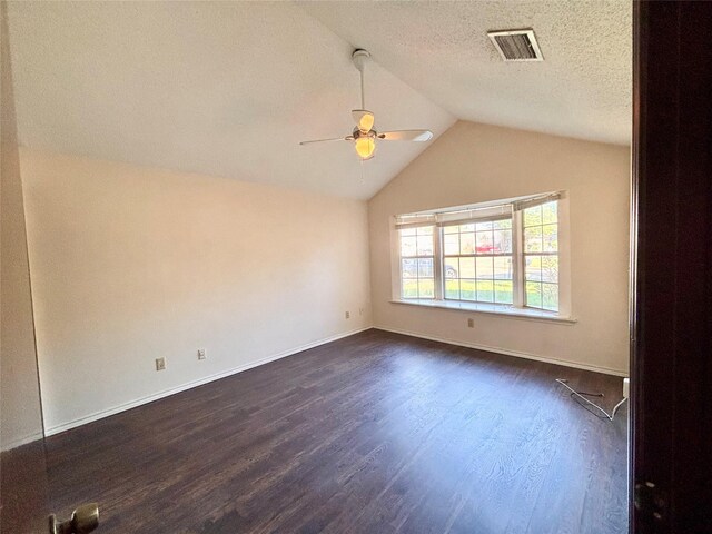 2505 Montclair Ln, Mesquite, TX 75150 - empty room featuring baseboards, vaulted ceiling, dark wood-style floors, visible vents, and a ceiling fan