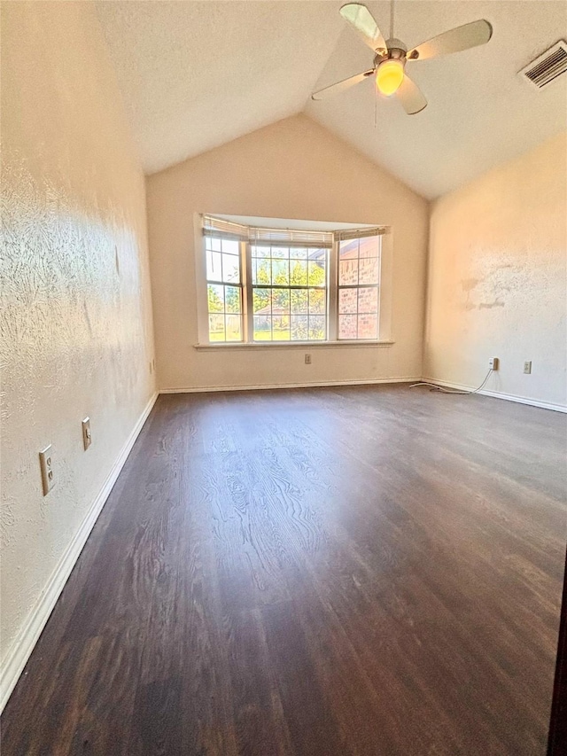 2505 Montclair Ln, Mesquite, TX 75150 - empty room with dark wood finished floors, vaulted ceiling, baseboards, visible vents, and a ceiling fan