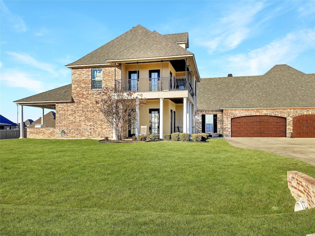 view of front of property featuring roof with shingles, a front lawn, a balcony, an attached garage, and driveway